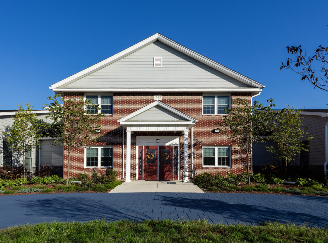 A house from a front door view with a large entrance and red double doors.