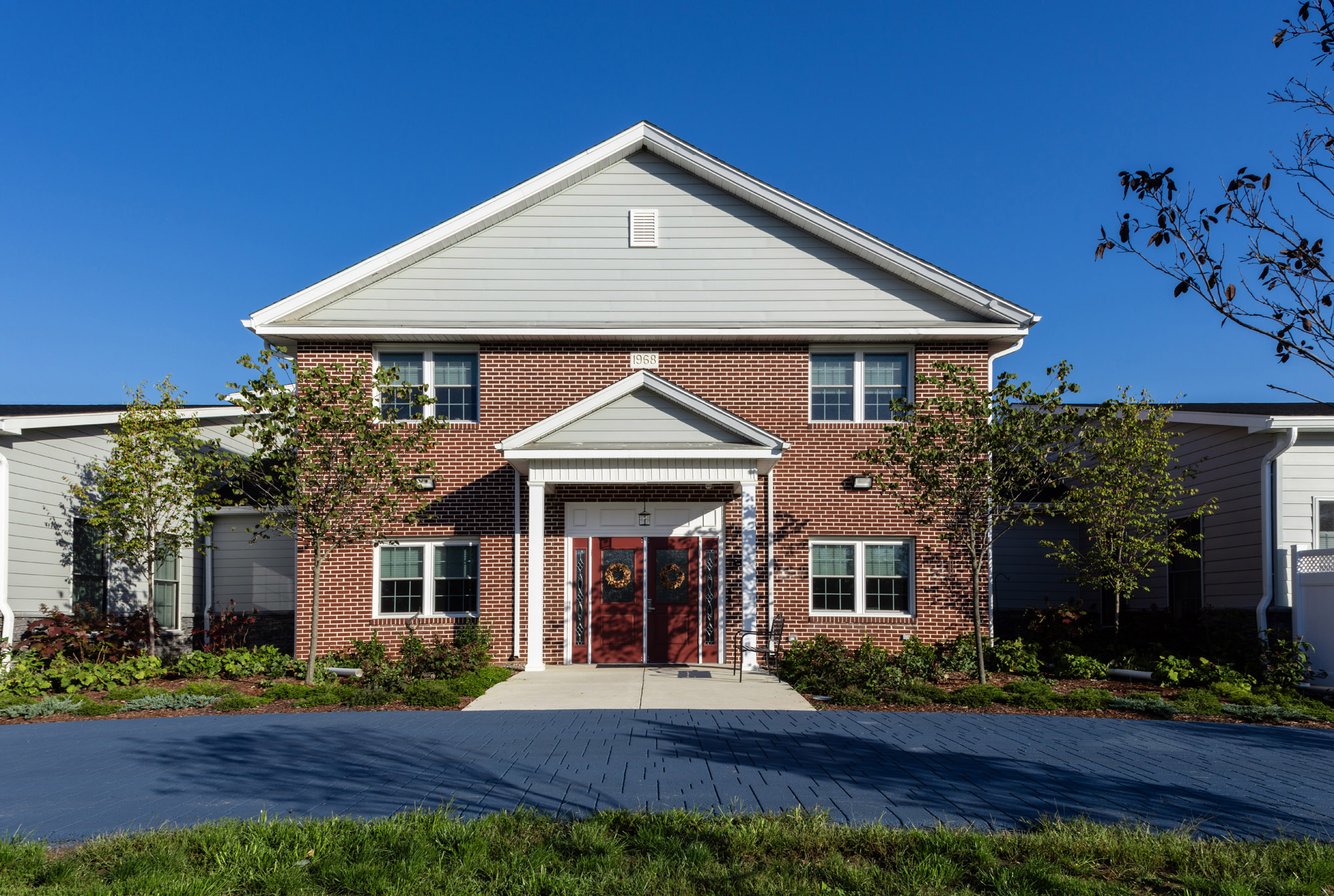 A house from a front door view with a large entrance and red double doors.